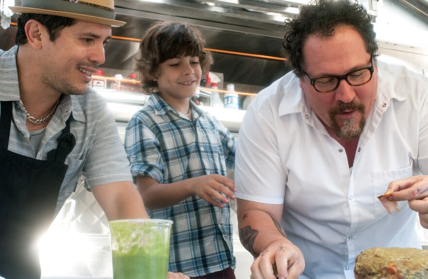 In <em>Chef</em>, Jon Favreau (right) plays a chef who leaves his post at a respected LA restaurant to launch a food truck with his son (Emjay Anthony, center) and a former line cook (John Leguizamo).