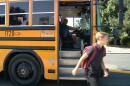 A WCSD bus driver watches a student walk away from the bus from his driver's seat after dropping him off.