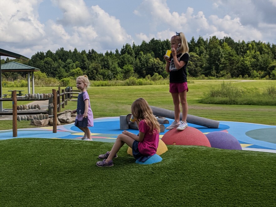 Three children play on a playground.