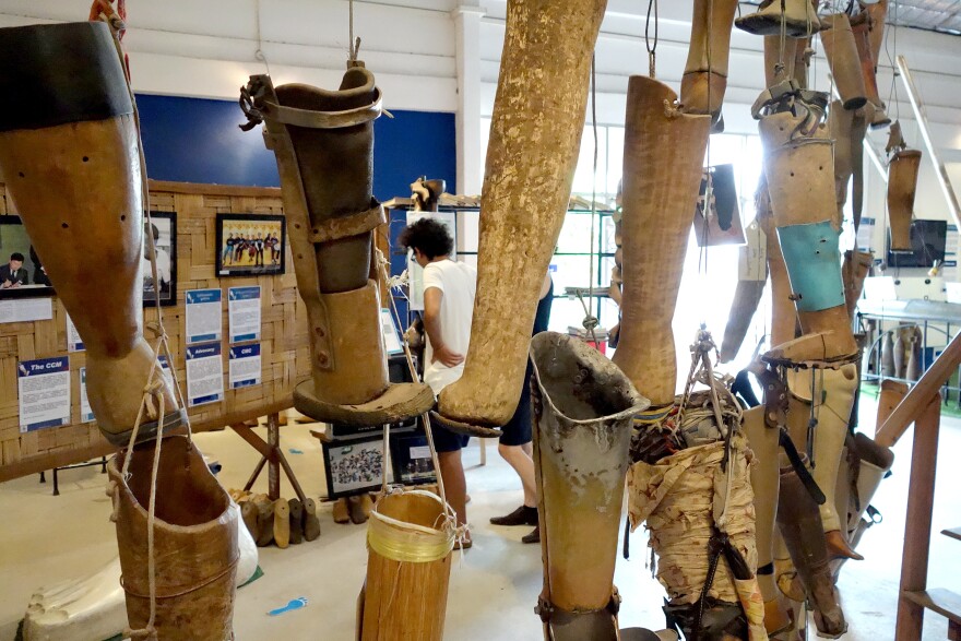 Homemade artificial limbs hang at the COPE Visitor Center. The Cooperative Orthotic and Prosthetic Enterprise is a nonprofit organization in Laos. The makeshift prosthetic legs, some of them clearly just rudimentary pieces of sanded wood, were donated by bombing survivors after use.