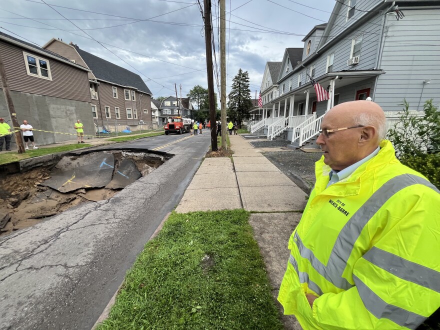 Wilkes-Barre Mayor George Brown looks over a sink hole on Horton Street in the city that opened up on June 25.