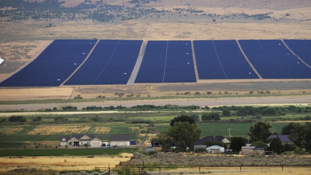 A solar farm sits behind homes Tuesday, Aug. 9, 2022, in Mona, Utah. The U.S. has renewed credibility on global climate issues and will be able to inspire other nations in their own efforts, experts say, after the Democrats pushed their big economic bill through the Senate on Sunday, Aug. 7. (AP Photo/Rick Bowmer)