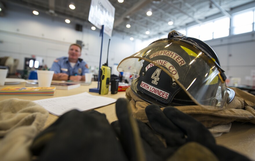 Firefighter gear on a table at a volunteer fair in Georgia, as a local volunteer firefighter explains the job.