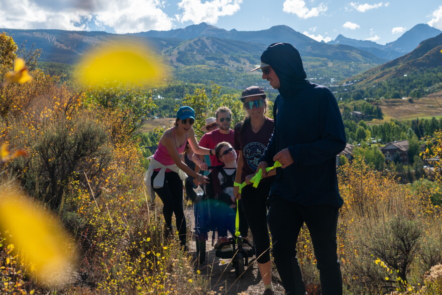 Challenge Aspen “Solemates” runners Zach Benevento-Zahner (right, in foreground) and Olivia Niosi (second from right) help guide Tanner Fatsuko in an all-terrain wheelchair called a “GRIT Freedom Chair” on the trails of Snowmass Village on Sept. 21, 2023. Daniele Mottier and Daniel Shnider help guide the chair from the back. The adventure was part of a training session for the "Solemates" team that trains for long-distance trail races while fundraising for Challenge Aspen’s adaptive recreation programs.