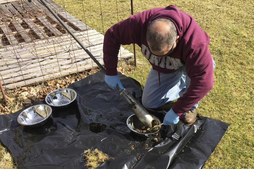 Stew Brodell takes a sample of soil near a private well that was contaminated with PFOA in North Bennington, Vt.