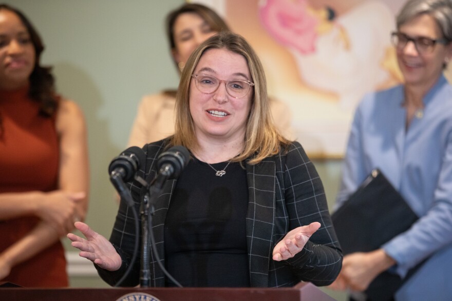 A white woman speaks at a lectern.