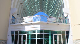 Entrance of the Guam Museum, located in Hagatna. The entrance is covered with glass windows, and a triangular white cement roof. 