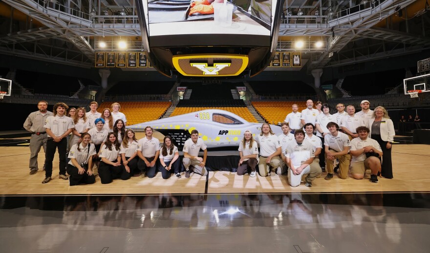 a team of students in front of a new solar car they built
