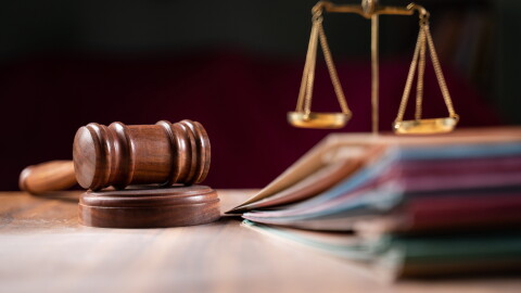 focus on hammer, group of files on judge table covered with dust - concept of pending old cases or work at judicial court.