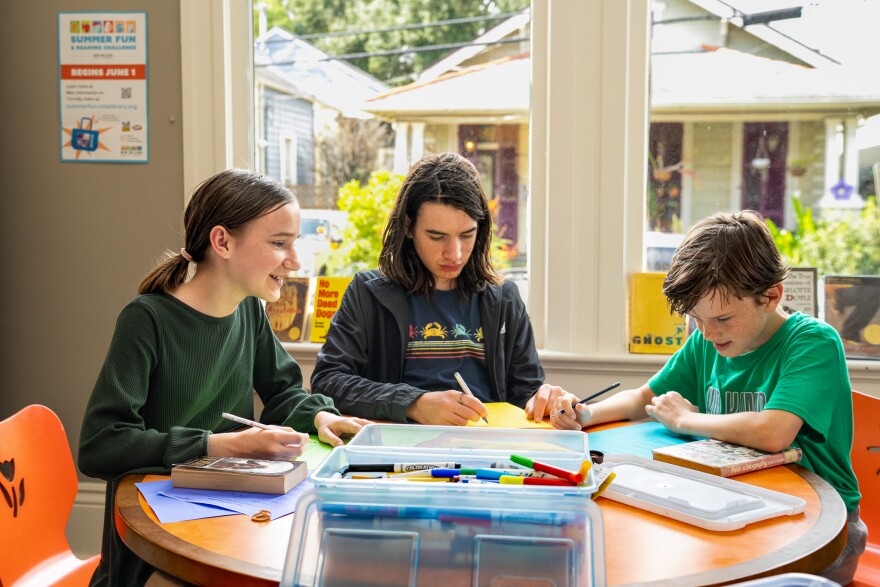 Siblings, Ada, 12, Charlie, 14, and Jack, 10, attend a middle school book club at the Cita Dennis Hubbell Library on July 30, 2026.