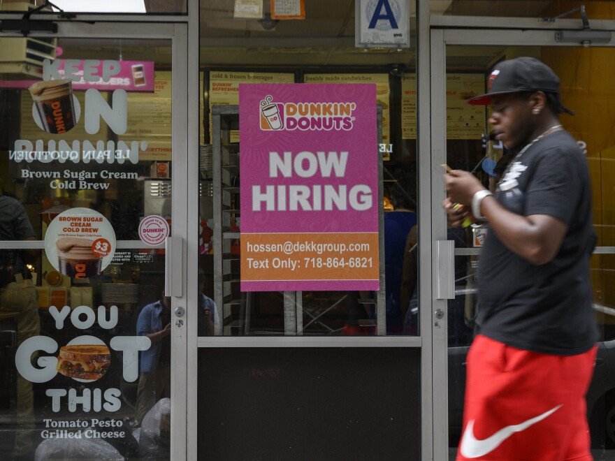 A man walks past a "Now Hiring" sign in New York City on July 8, 2022. Economists and the Federal Reserve are looking for signs that job growth cooled in September, which could help with uncomfortably high inflation.