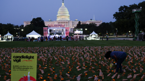 A demonstrator stands among battery powered candles in paper bags during a vigil in protest against potential cuts to Medicaid in Washington, D.C. on July 23, 2025.