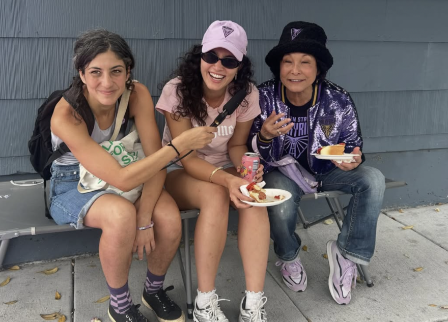 KALW News chats with Valkyries fans, including Lillian Shiiba (far right) wearing a sparkly violet jacket and GSV bucket hat before Game 1 of the WNBA semi-finals on October 4, 2026.