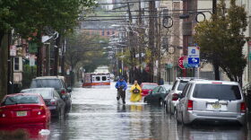 Residents walk through flood water and past a stalled ambulance in the  aftermath of Superstorm Sandy on Tuesday, Oct. 30, 2012 in Hoboken, NJ. (Charles Sykes/AP)