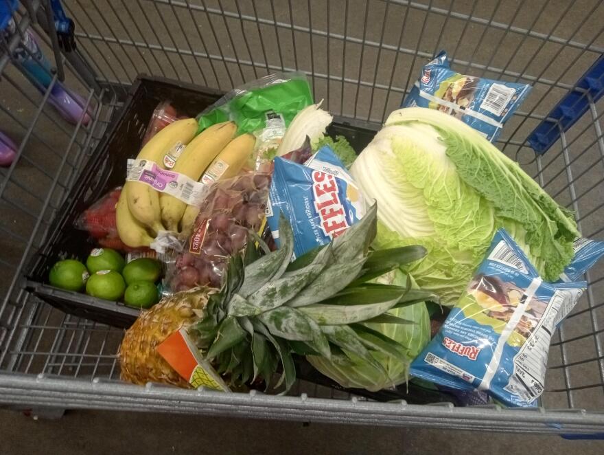 an overhead look at a grocery cart filled with fresh fruit and vegetables 