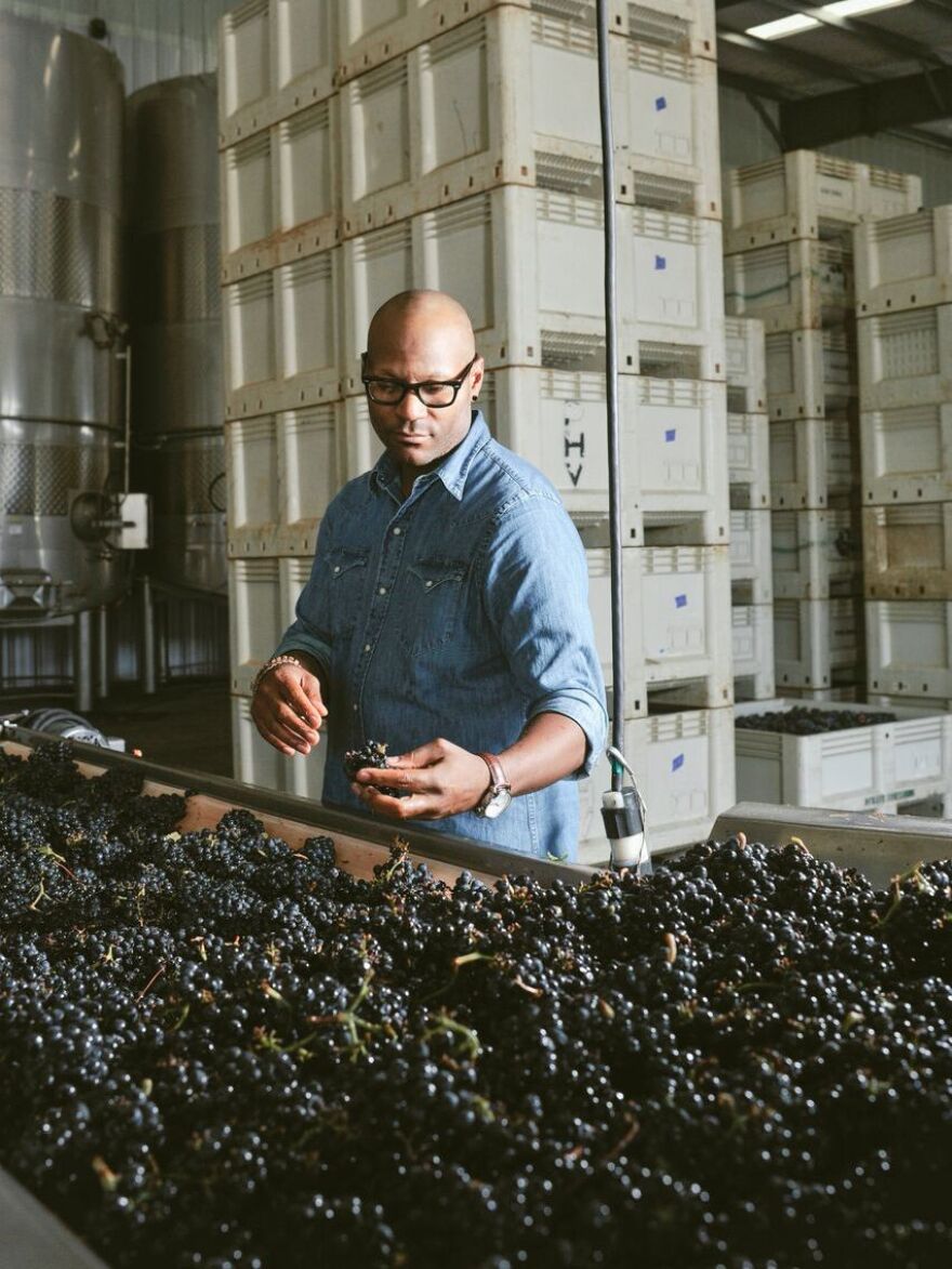 Andre Mack looks at grapes.