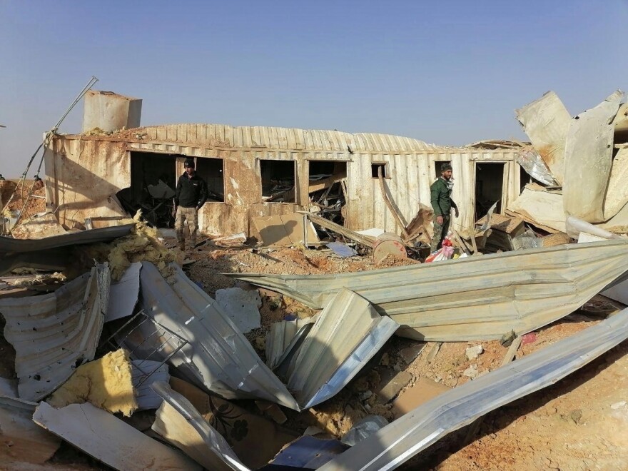 Fighters from the Kataeb Hezbollah militia inspect the destruction of their headquarters on Monday in the aftermath of a U.S. airstrike in Qaim, Iraq.