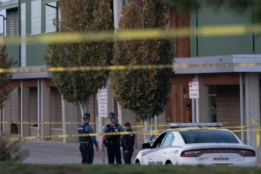 Officers behind yellow caution tape outside a school.