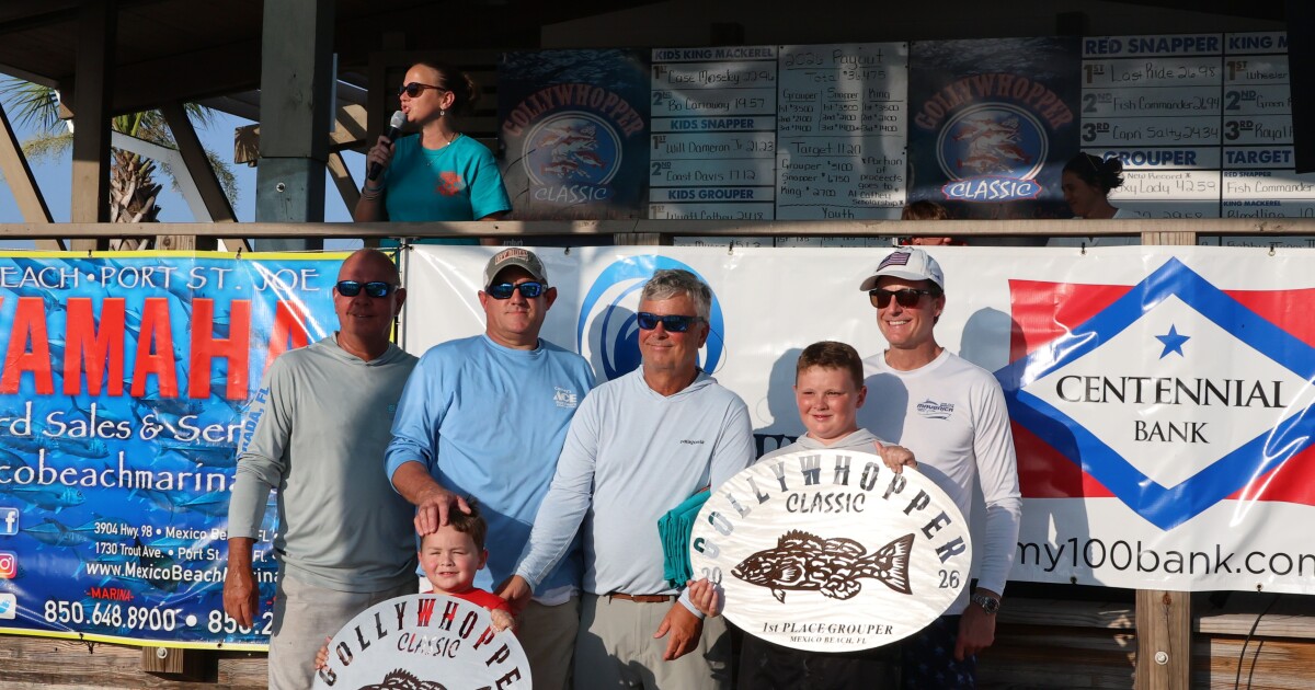 Group of men stand with their plaques that denote them as having caught the largest fish in the tournament for the youth division and overall