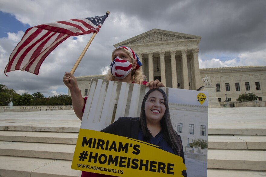 Women holding banner and U.S. flag in front of U.S. Supreme Court