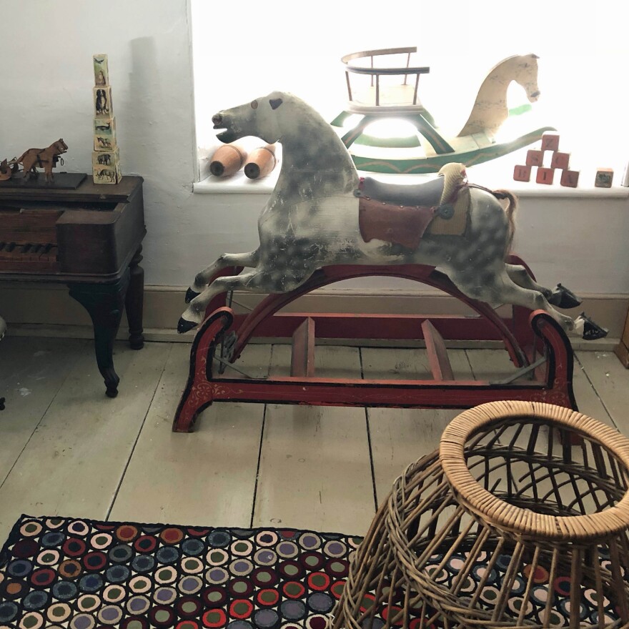 A room at the Old Stone House Museum that is dedicated to antique toys, including an old rocking horse by the window.