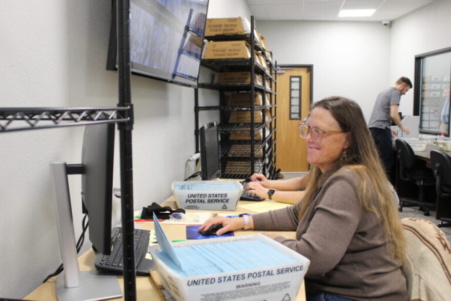 A worker at the Linn County Clerk’s Office compare the signature on each ballot envelope with that of the person’s voter registration.