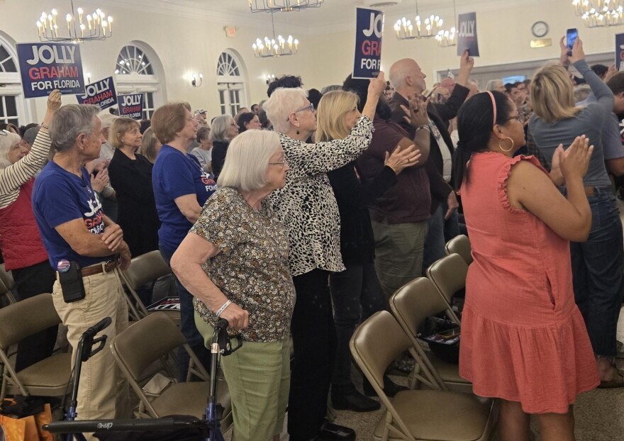 People stand and clap as Democratic gubernatorial candidate David Jolly takes the stage at a campaign rally at the Gainesville Woman's Club on Wednesday, Oct. 28, 2026. (Sofia Dinka/WUFT News)