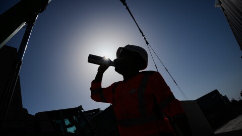 A worker drinks water on a construction site during high temperatures Wednesday, June 24, 2026. (AP Photo/Christophe Ena)