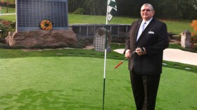 <p>Memorial Golf Park creator Arne Swanson stands on its putting green — an ossuary with enough capacity to hold 600 former avid golfers. Families can purchase a spot on the solemn "leader board" to preserve the loved one's standing for all eternity. </p>