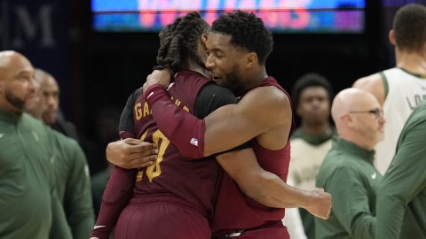 Cleveland Cavaliers guard Donovan Mitchell, right, hugs teammate guard Darius Garland, left, late in the second half of an NBA basketball game against the Milwaukee Bucks, Monday, Nov. 4, 2024, in Cleveland.