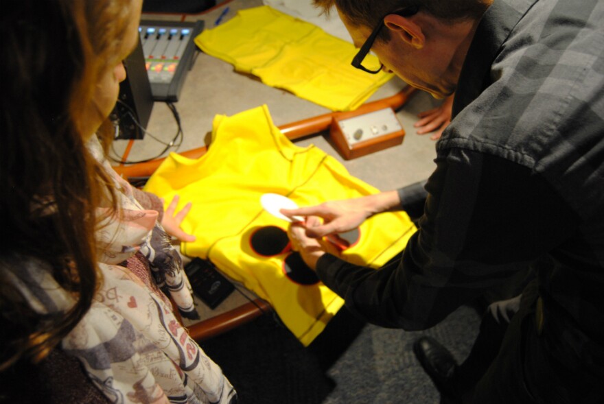 TWU student Arianne Scheller explaining to KERA's Justin Martin how their shirt helps combat back problems in space.