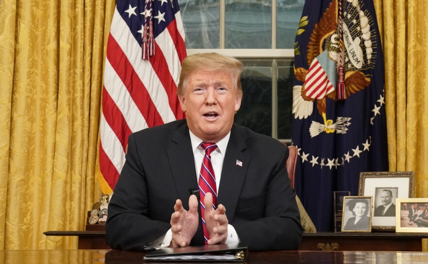 As seen from a window outside the Oval Office, President Donald Trump gives a prime-time address about border security Tuesday, Jan. 8, 2018, at the White House in Washington.