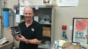 UCF Professor Josh Colwell holds up a prototype of one of the low-Earth orbital experiments. 