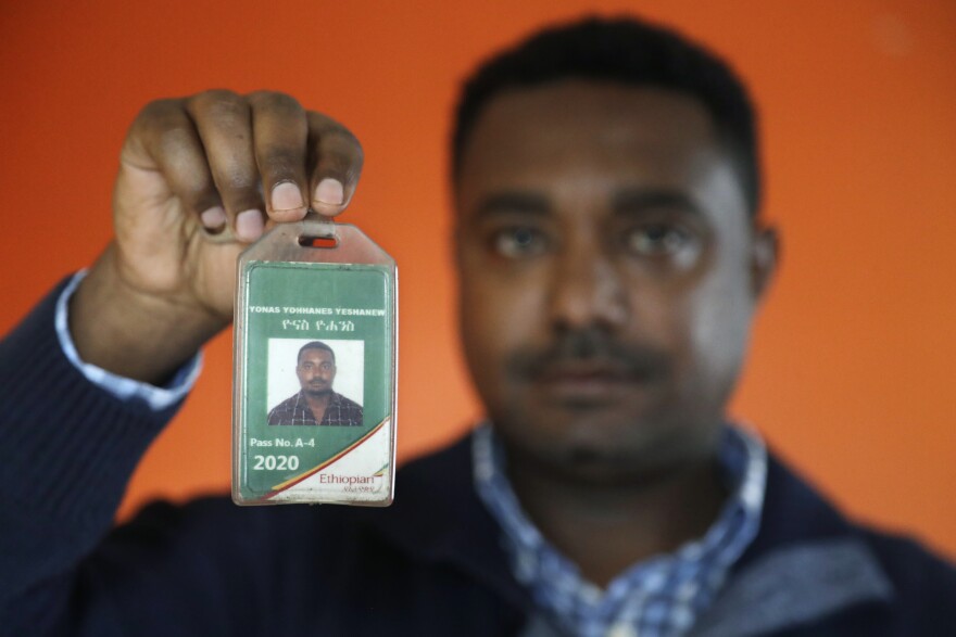 In this photo taken Sept. 24, 2019, Yonas Yeshanew, who resigned as Ethiopian Airline's chief engineer this summer and is seeking asylum in the U.S., poses with his company's identification card in the Seattle area. 