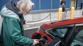 Loie Hayes plugs in her car at a charging station in Boston. (Robin Lubbock/WBUR)
