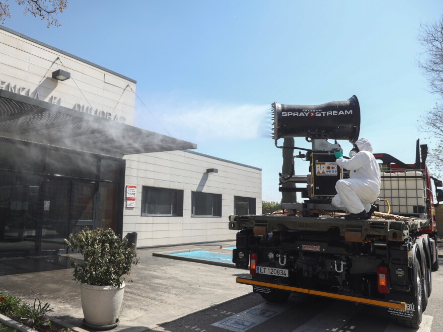 The Spanish Ministry of Health says the country has 47,610 coronavirus cases — and more than 3,400 people have died from COVID-19. Here, a member of the Emergency Military Unit disinfects buildings in Getafe.