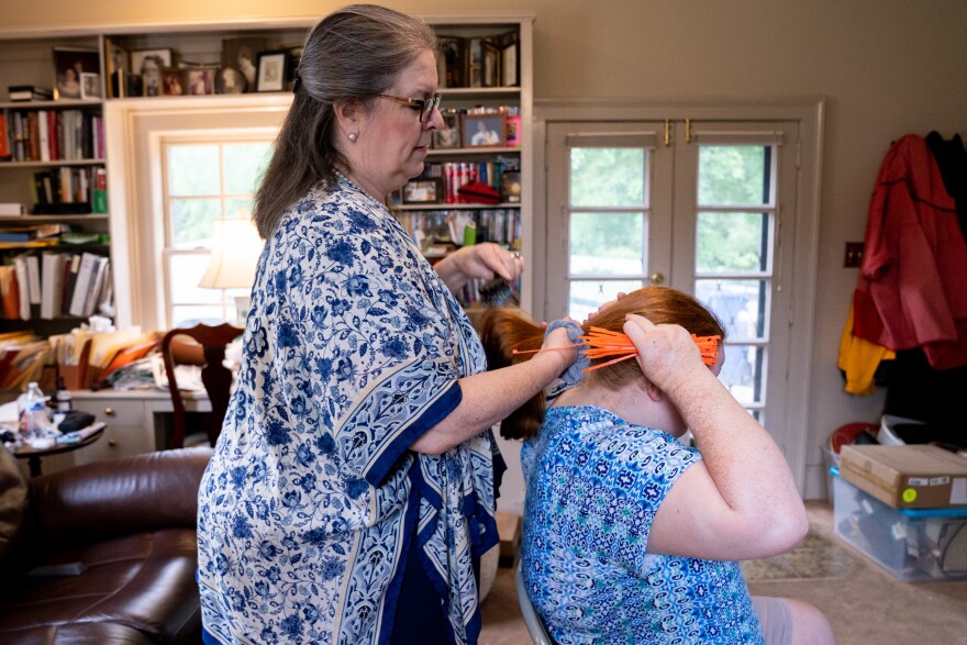 Carolyn Shofner brushes her daughter's hair at their home in Nashville, Tenn. Rachel has severe autism and struggled to learn remotely without the paraprofessional who sits by her side in school.