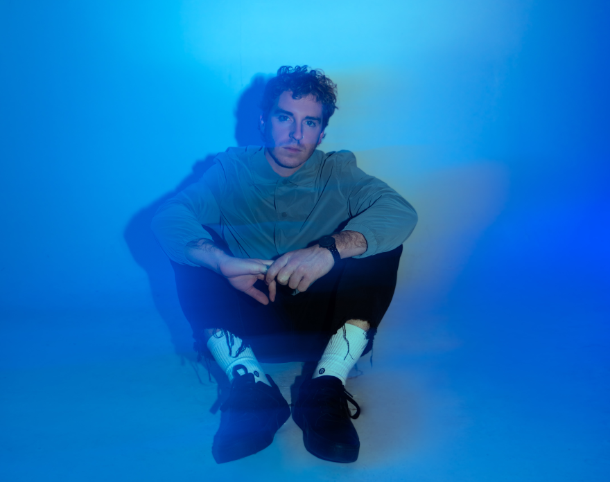 Nate Saggio poses for a portrait under blue light