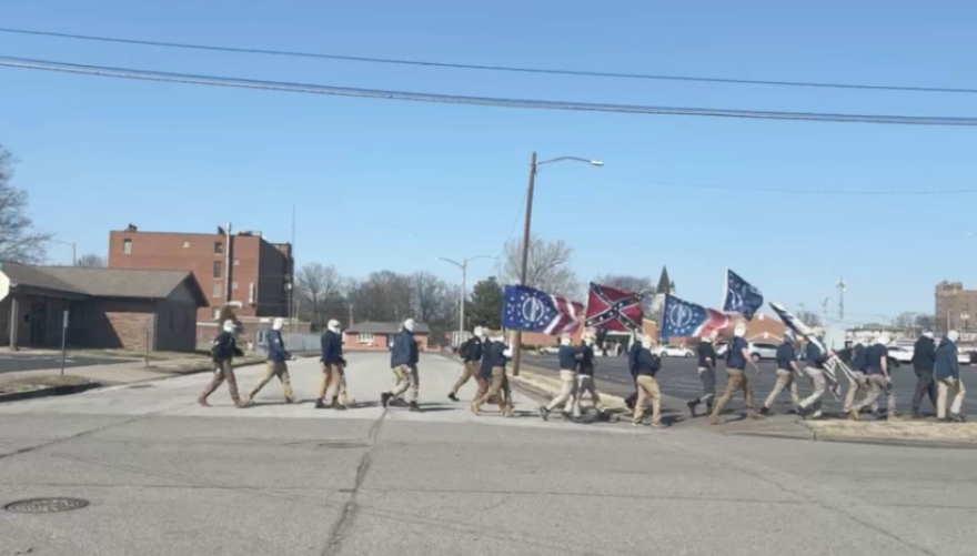 A group of masked individuals carrying white supremacist and Confederate symbols march near the McCracken County Courthouse in Paducah on Sunday, Feb. 25, 2024.