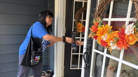Melissa Molina, a member of Grassroots Resistance, hands literature about candidates the organization supports to a resident in Bay Village a week before the election.