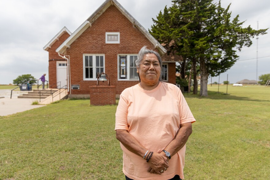 Kathleen Tahah stands in front of the Deyo Mission church, a historic site for Comanches.