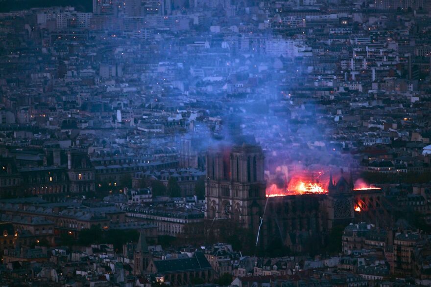 From Montparnasse Tower, flames and smoke can be seen billowing from the roof at Notre Dame Cathedral, about 2 miles away.