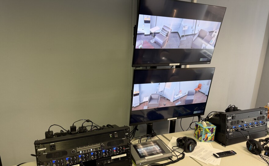 Licensed psychologists supervise student clinicians treating patients in the therapy rooms through these monitors, March 23, 2026.