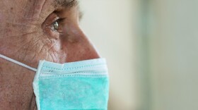 A photo of an elderly man wearing a face mask. 