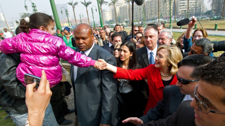 Secretary of State Hillary Clinton (in red) shook hands with a child as she visited Cairo's Tahrir Square earlier today (March 16, 2011).