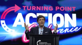 Tucker Carlson speaks at a conference.