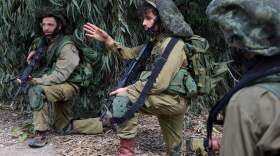 Israeli soldiers take up position in Kfar Aza, in the south of Israel, bordering Gaza Strip on Tuesday, Oct. 10, 2023.