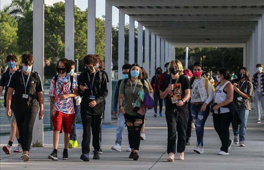  Cypress Bay High School students enter the campus in Weston on Broward County's first day of school. Students were required to wear masks, in defiance of new state rules.&#13;
