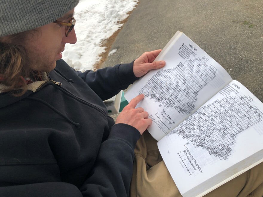 Doug Hitchcox, staff naturalist at Maine Audubon, flips through the original 1978-83 Maine atlas of breeding birds.