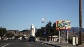 Looking down a paved road with the Kingman AZ Route 66 sign on the right